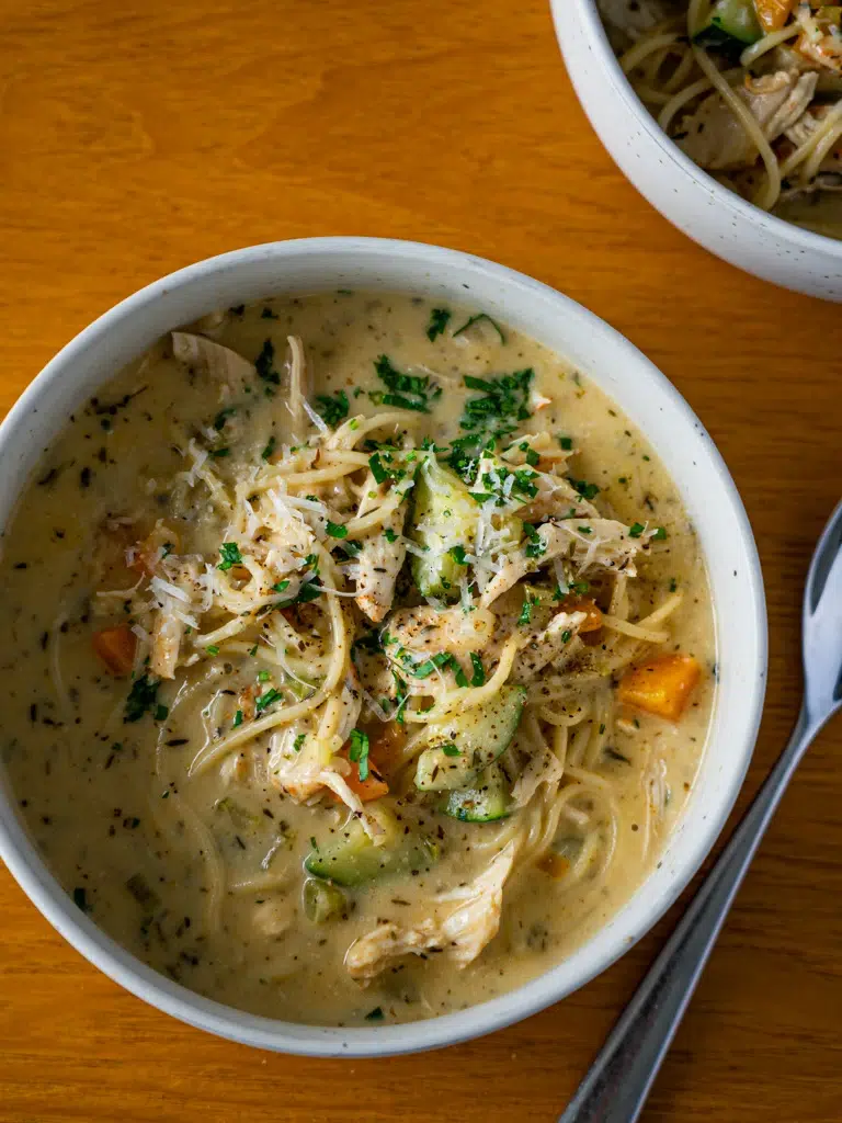 Overhead view of two bowls of creamy lemon chicken noodle soup